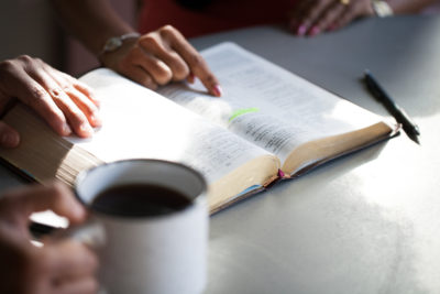 Women pointing at Bible verse