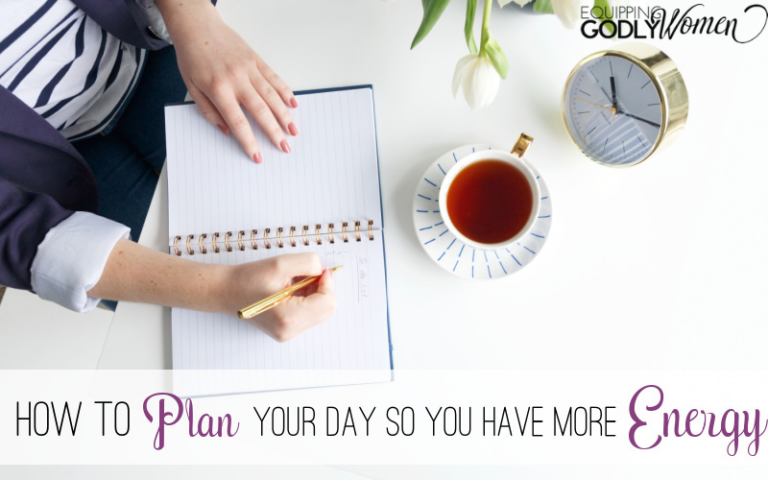 Woman planning her day writing in a planner.