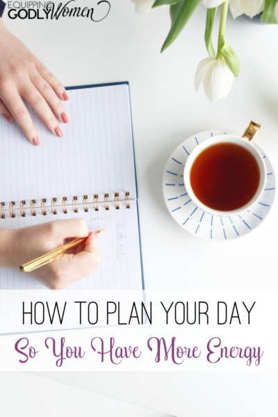 Woman planning her day writing in a planner.