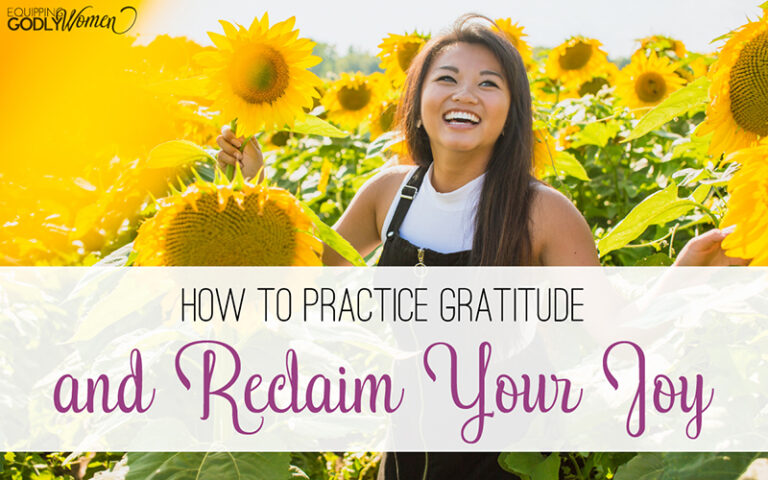 Woman in a sunflower field smiling and showing how to practice gratitude and reclaim your joy.