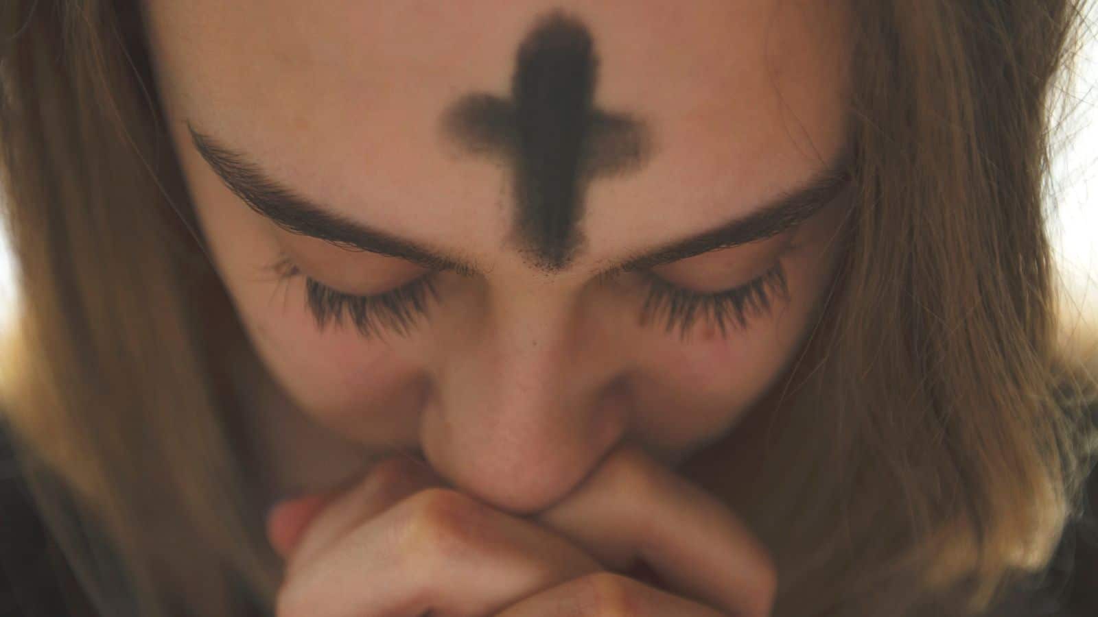 Woman praying with ashes on head