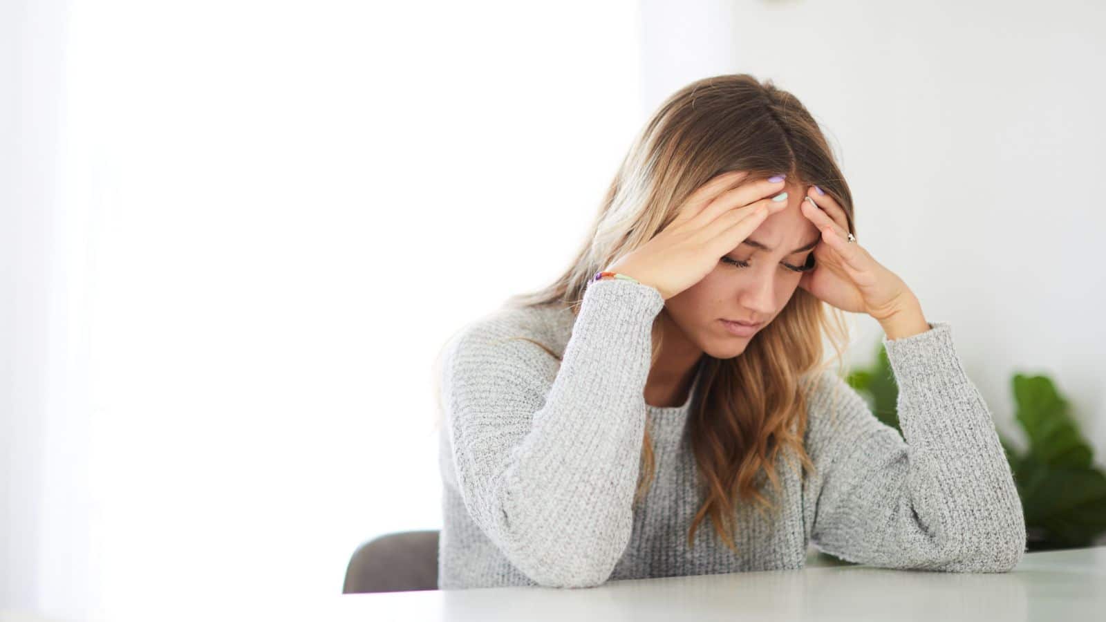 Worried woman with head in hands