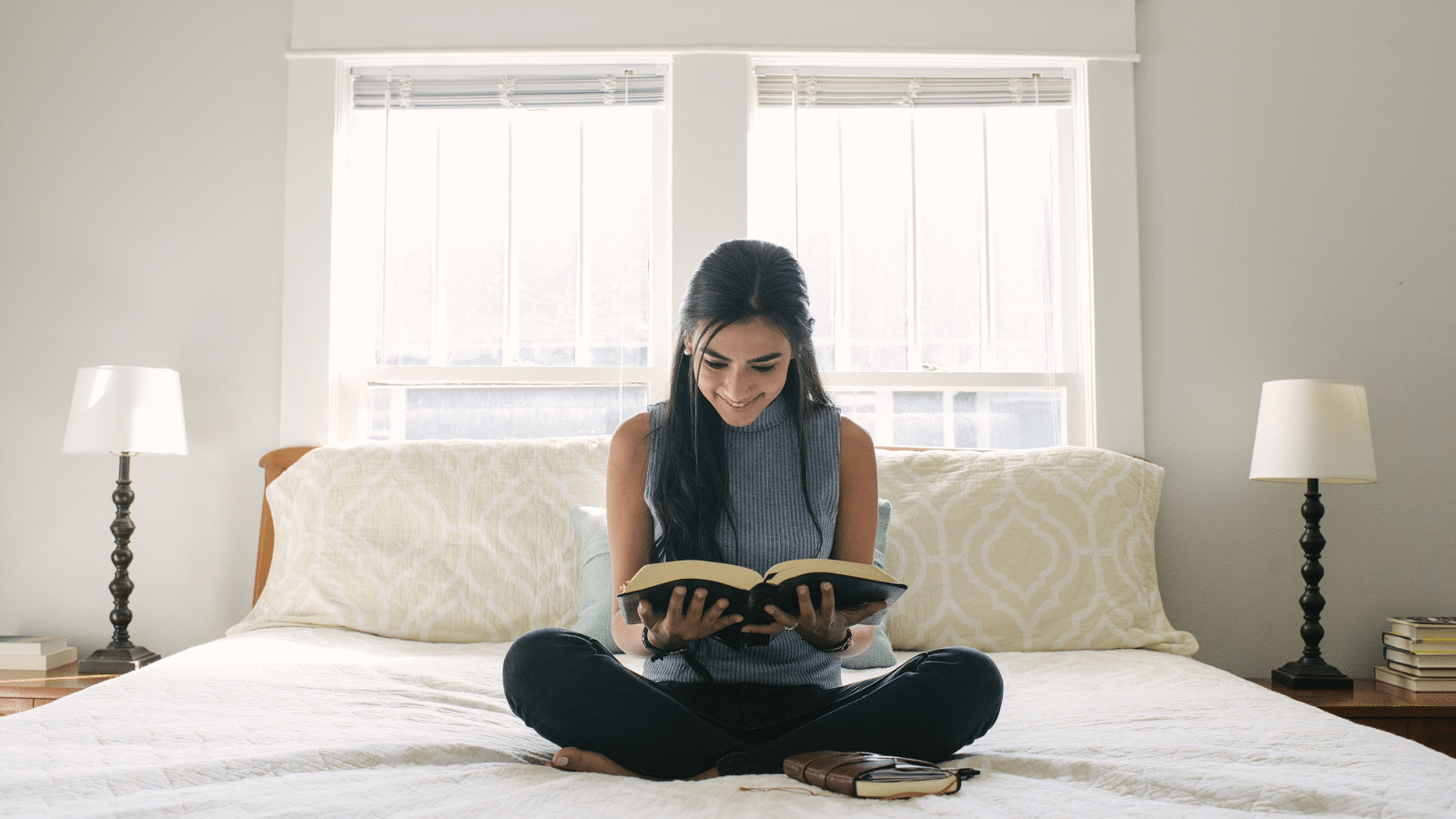 Woman reading the Bible on her bed