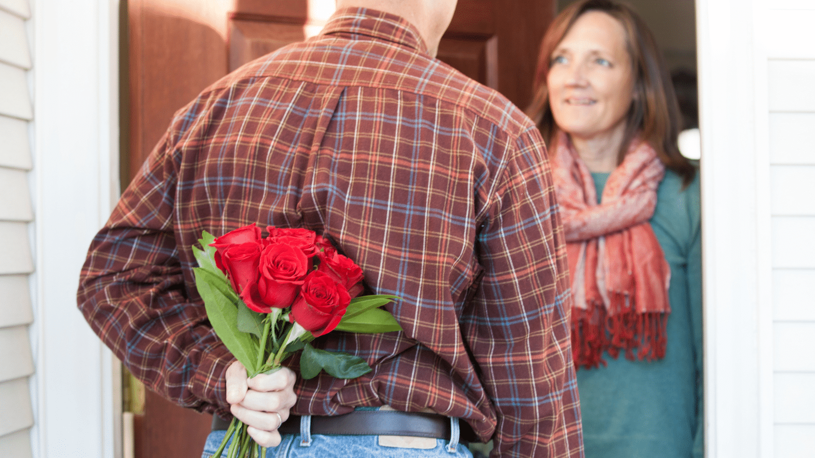 Man surprising his wife with flowers.