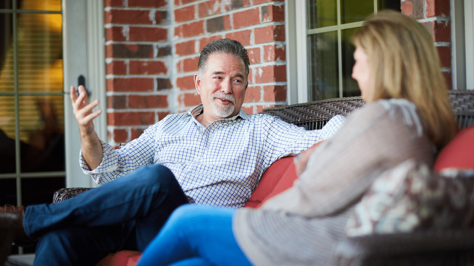 a couple sitting on a porch talking