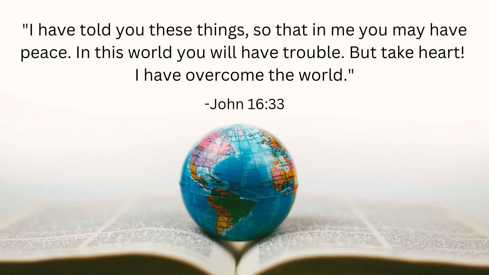 Bible with small globe on top with John 16:33