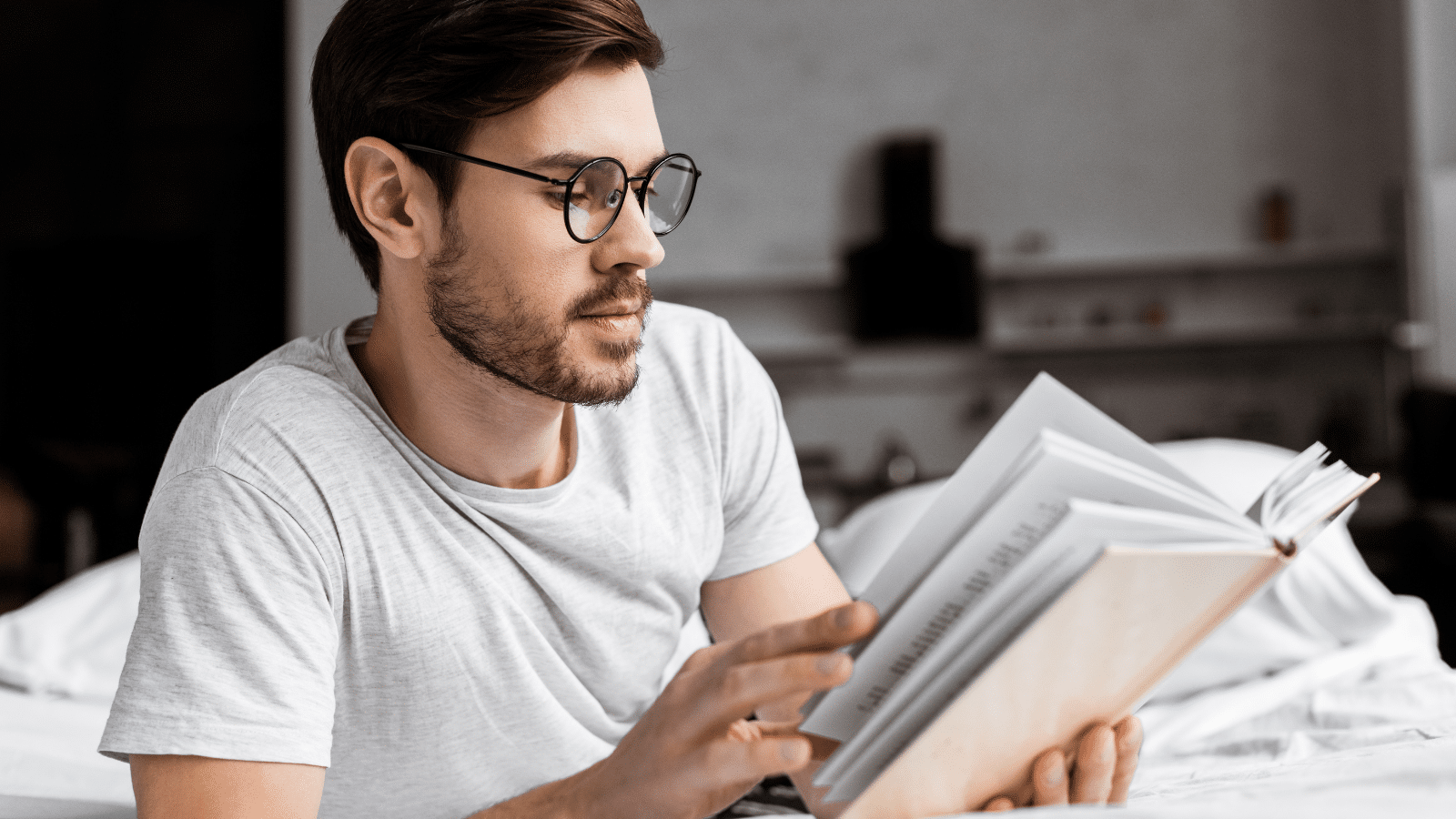 man reading in bed with glasses