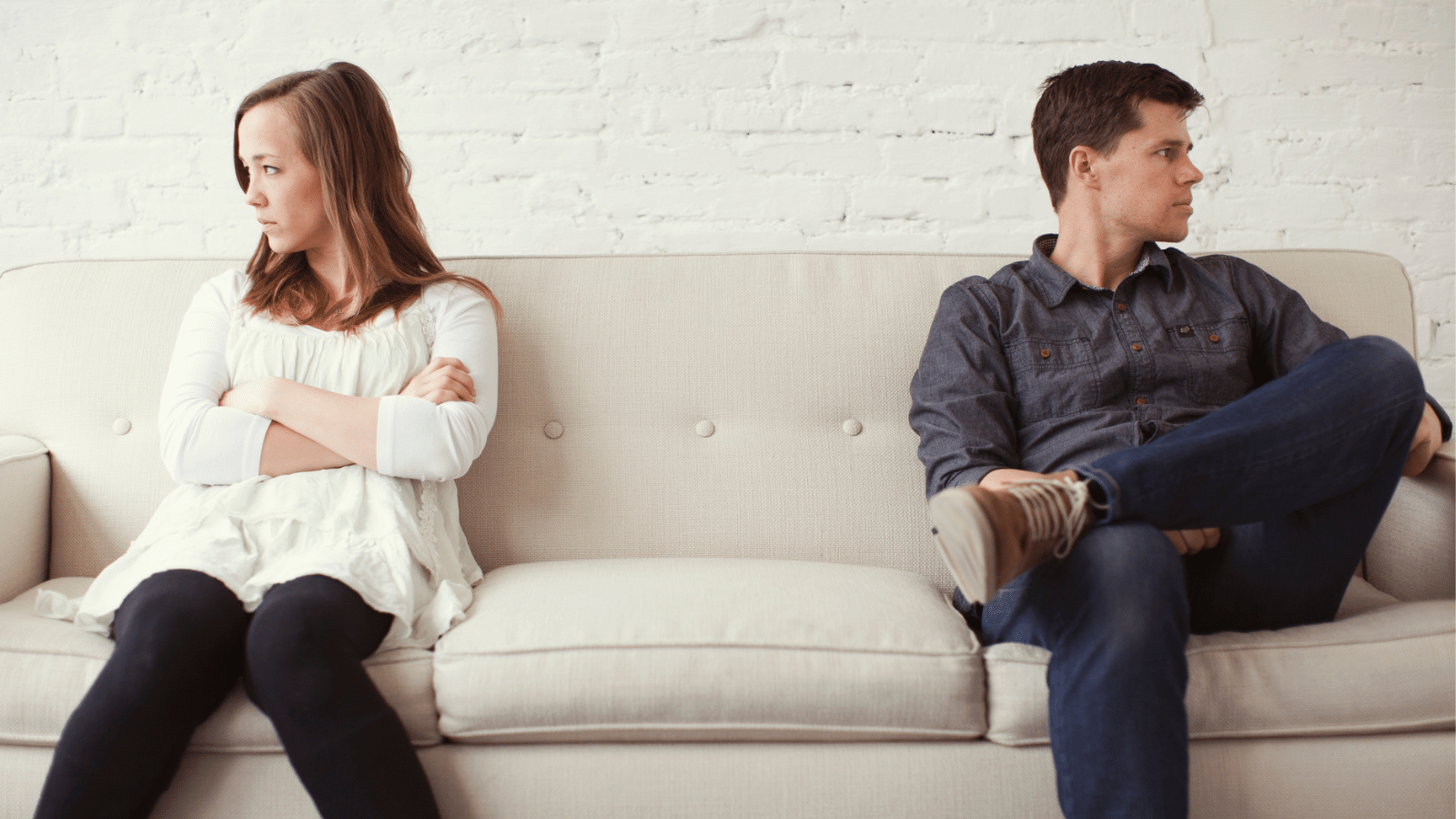 couple sitting on couch looking opposite directions