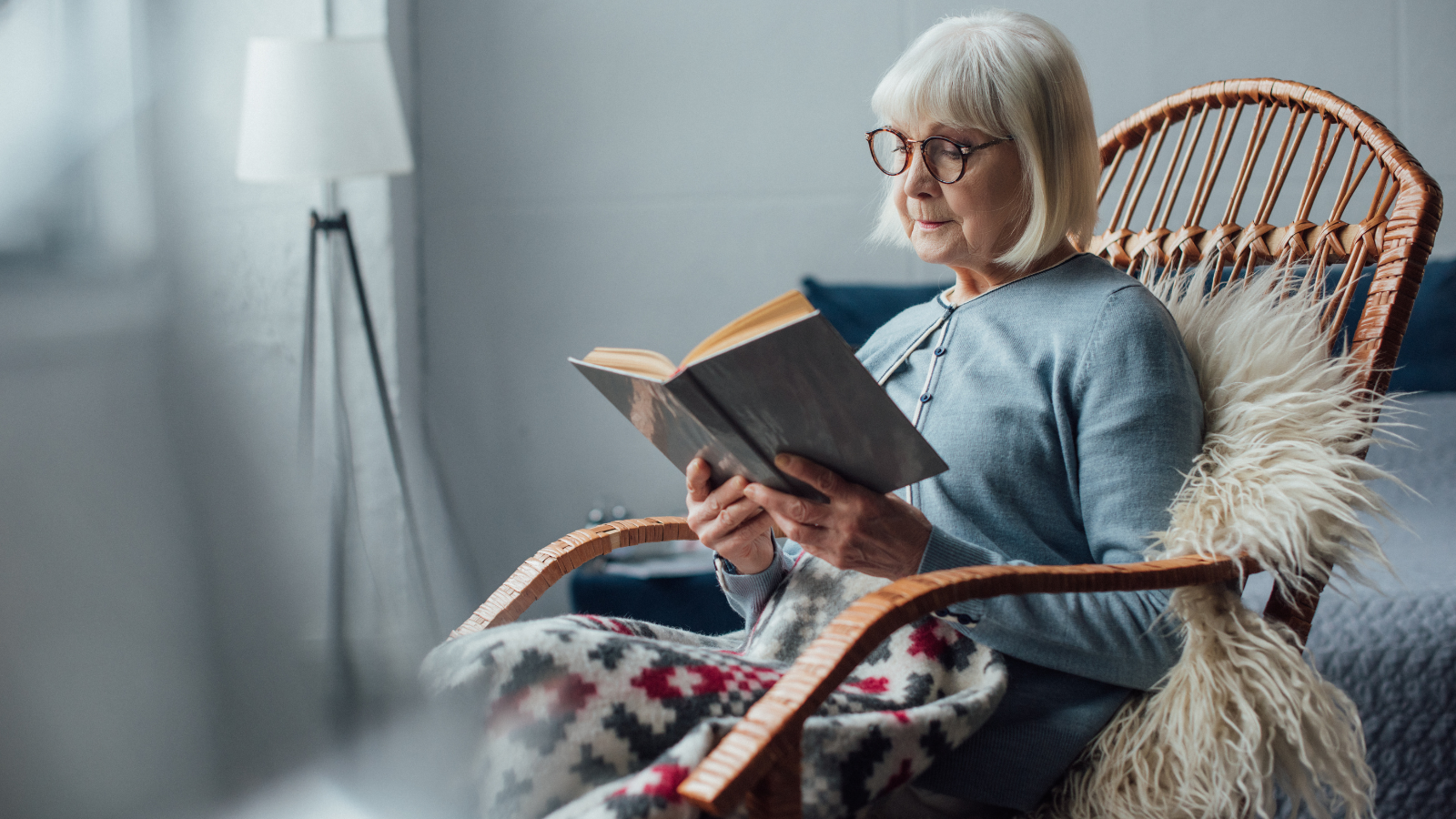 senior woman reading in a rocking chair