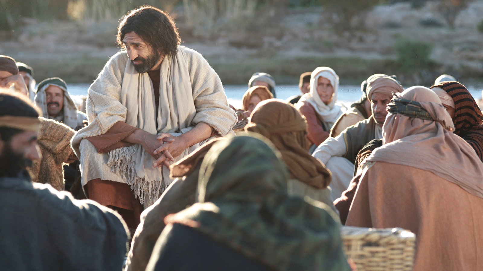 Jesus teaching parables to a crowd people circling around Him