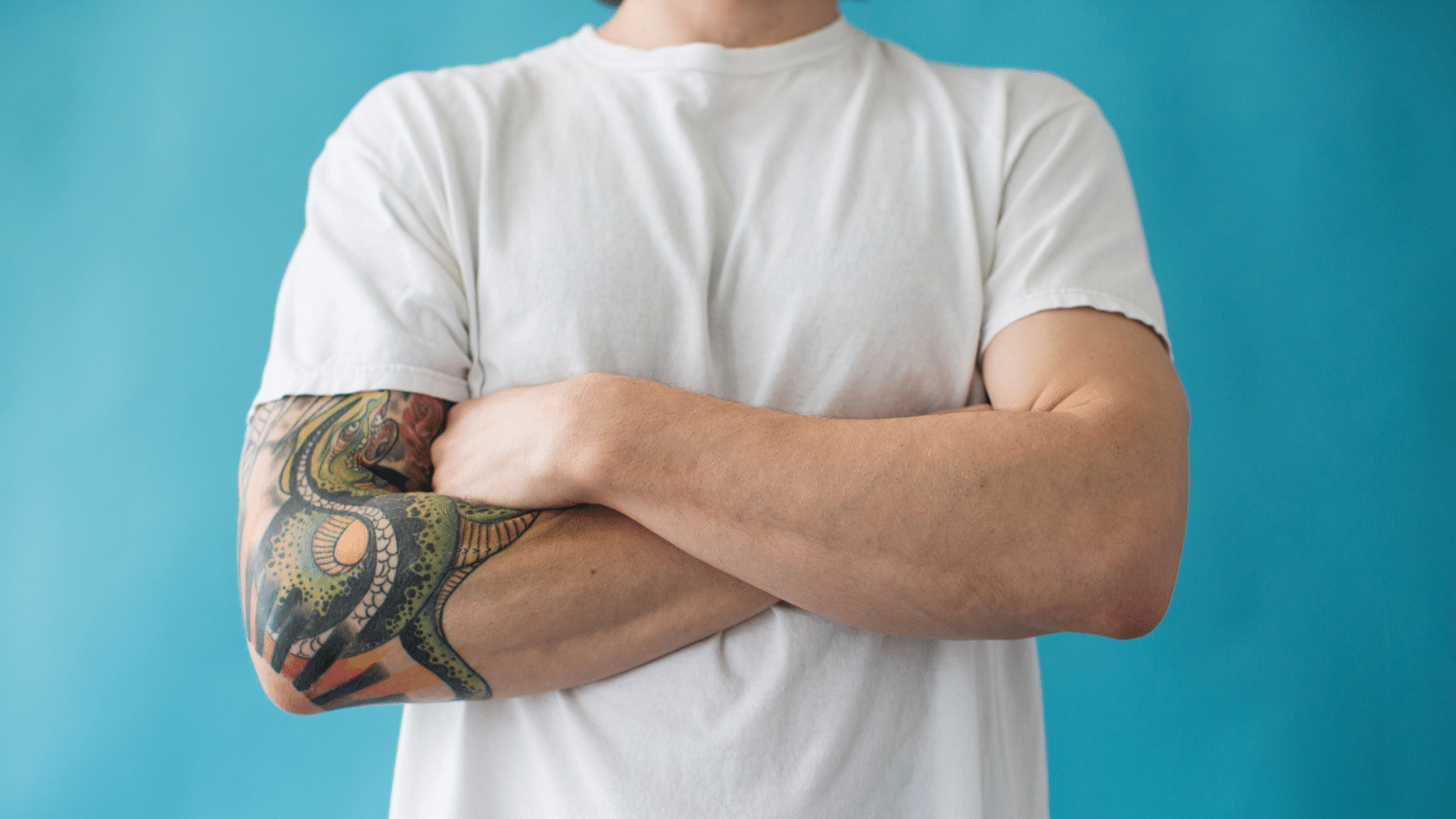 man crossing his arms with tattoos