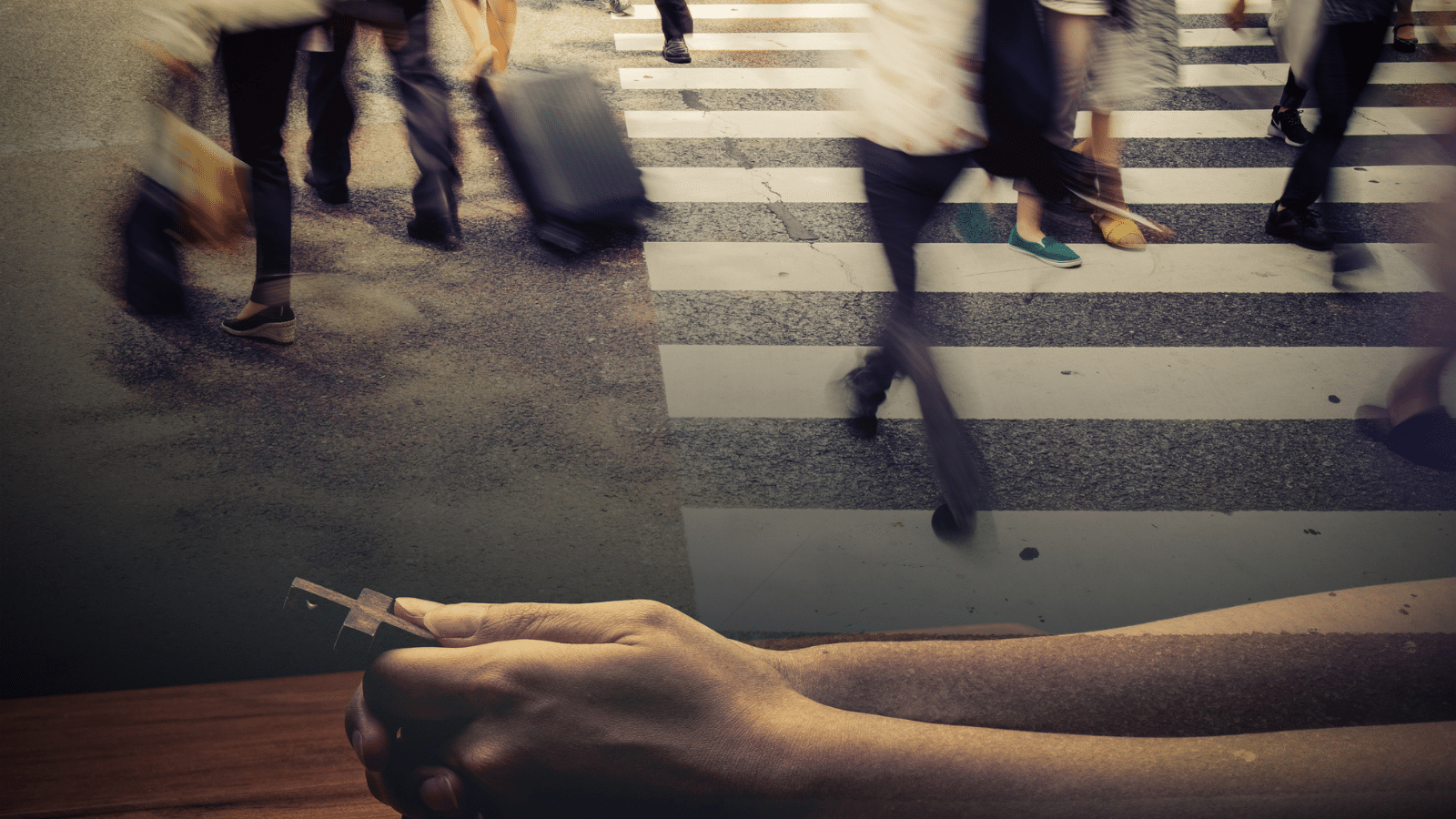 A double exposure image of people on a busy crosswalk and praying hands.