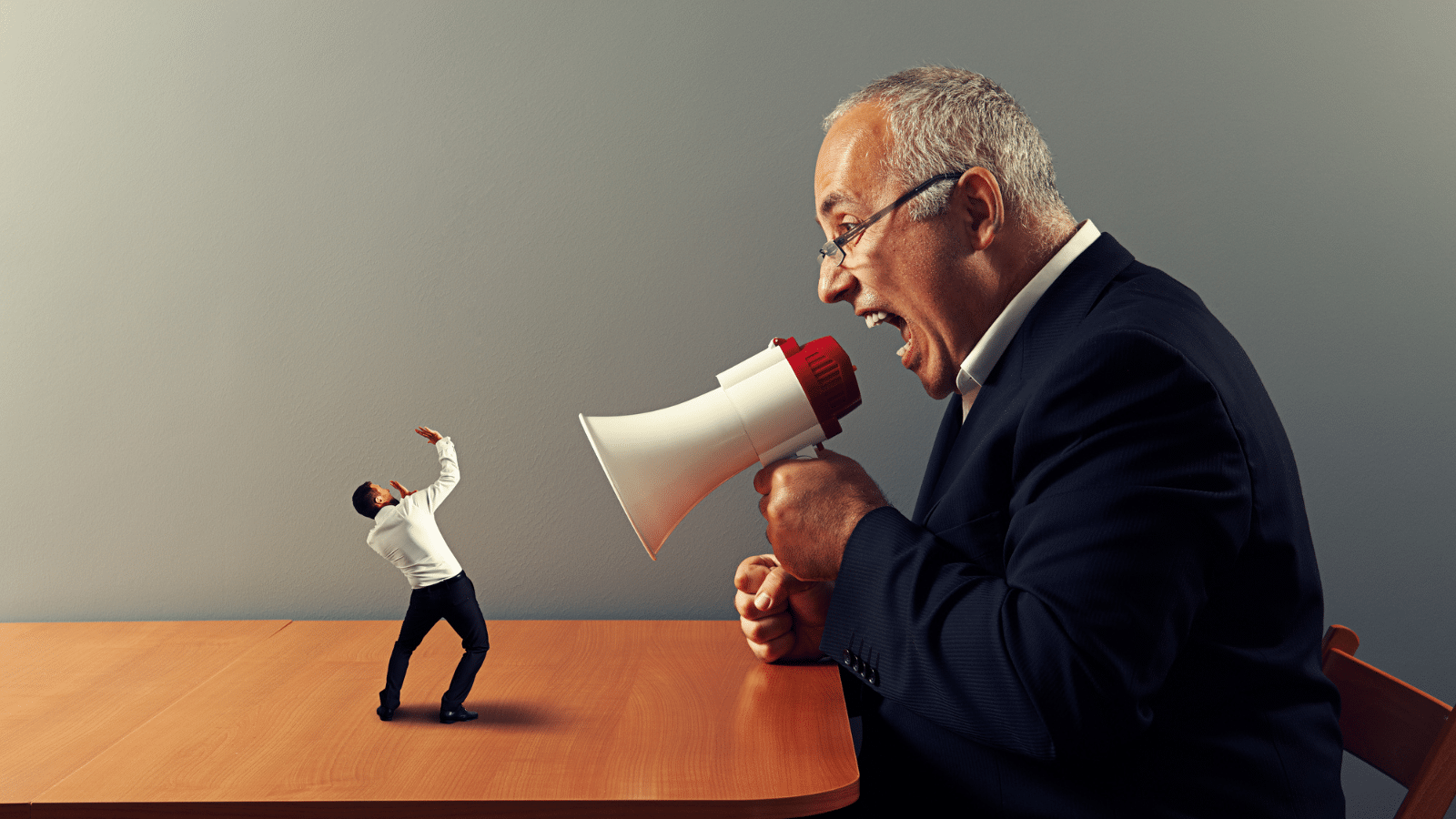 boss screaming at miniature employee with megaphone