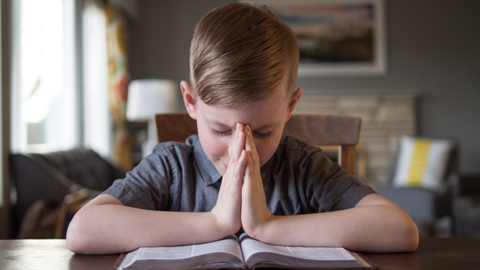 boy child reading the Bible and praying
