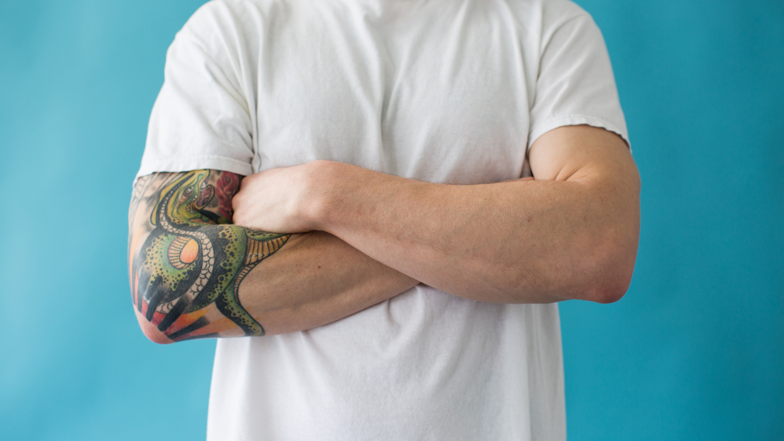 man crossing arms with tattoo
