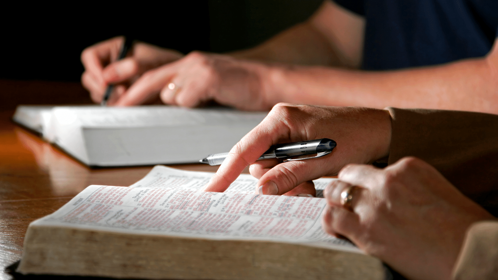 man pointing at Bible verse