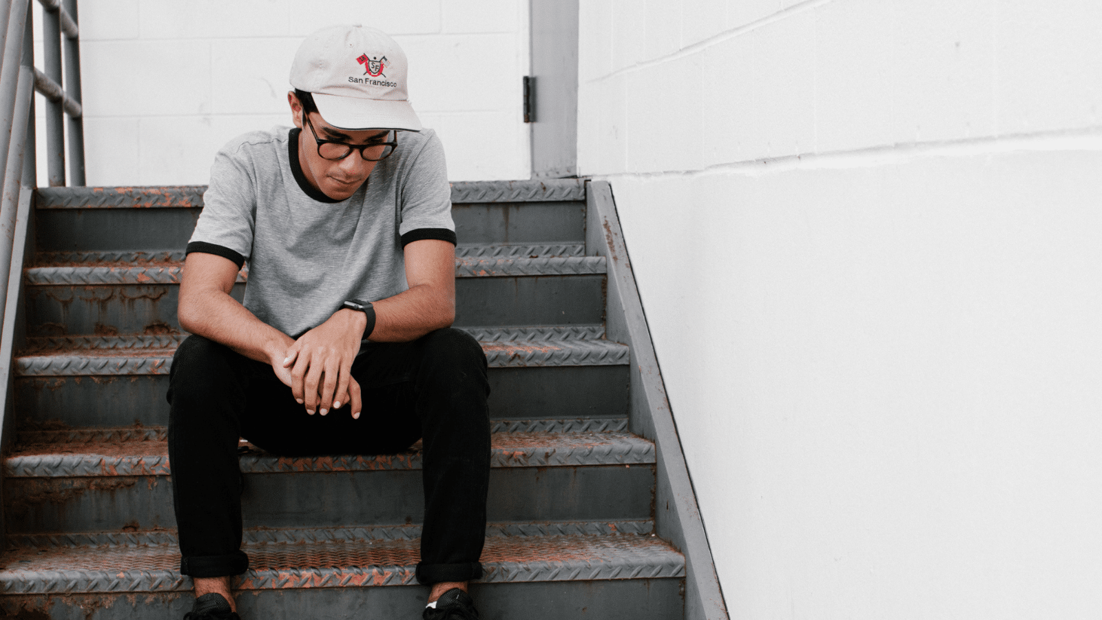 man sitting on stairs looking down