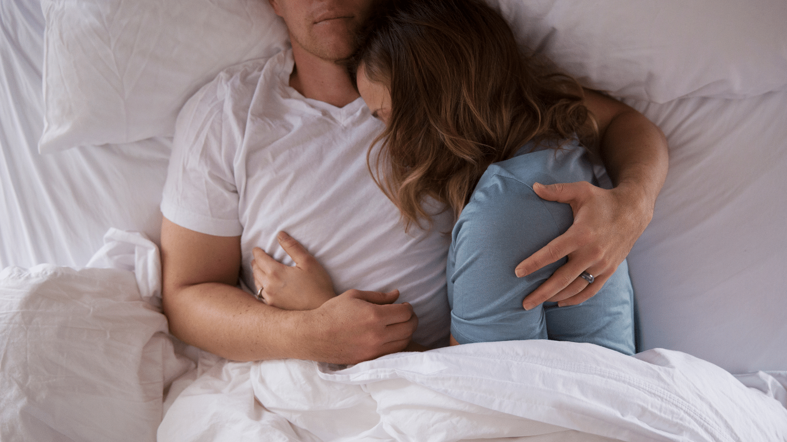 married couple snuggled in bed