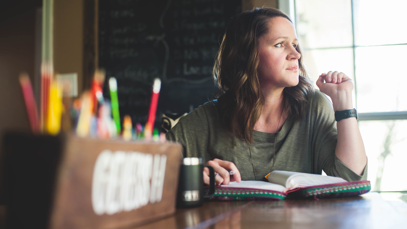 woman with Bible looking away thinking about trusting God