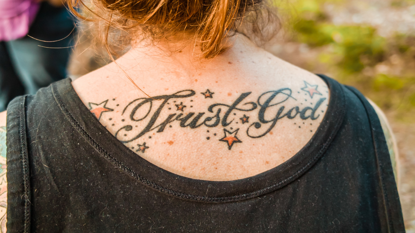 woman with trust God tattoo on her neck