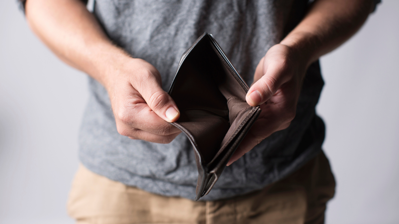 man holding empty wallet with no money