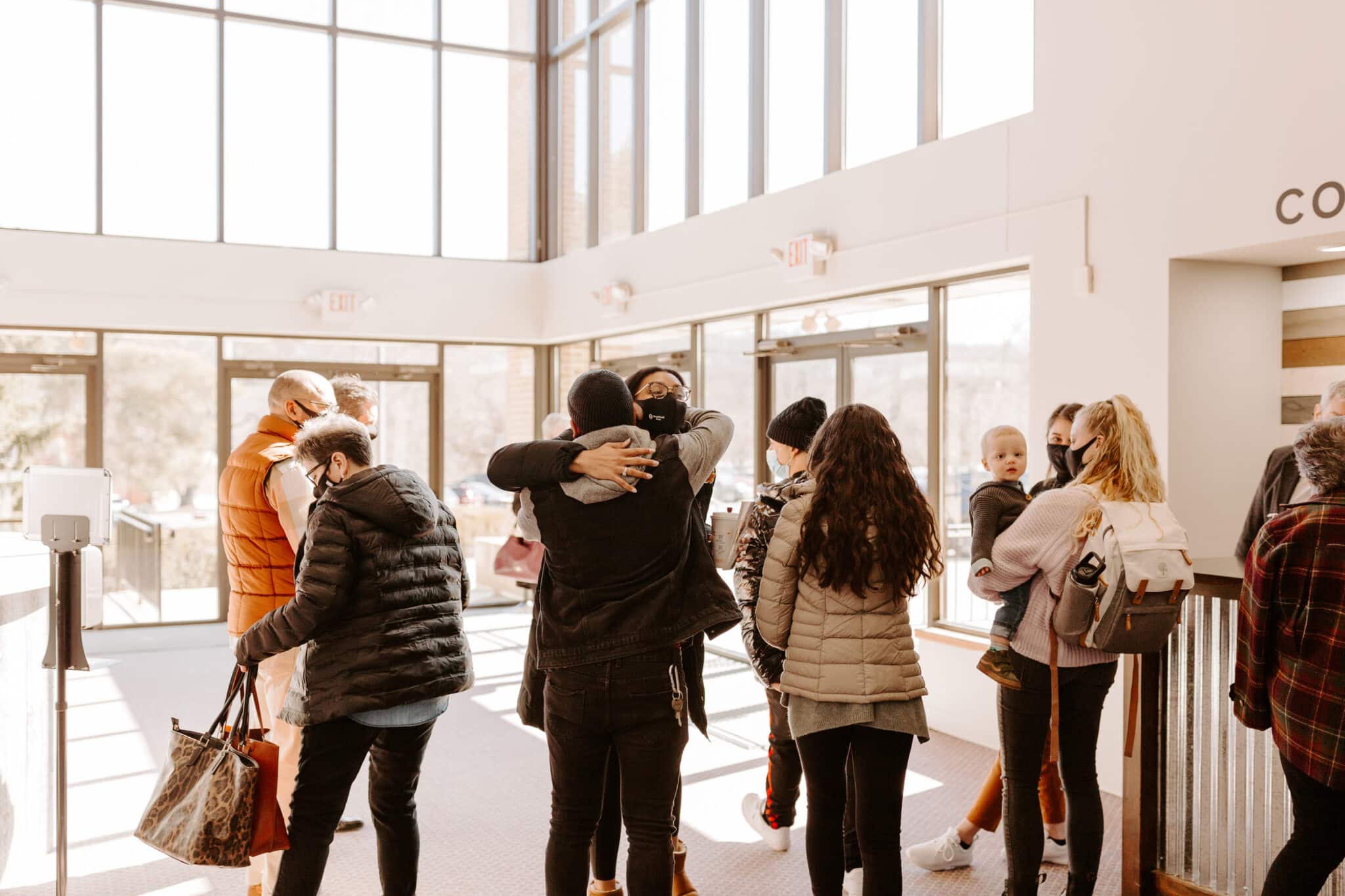 people hugging in church lobby