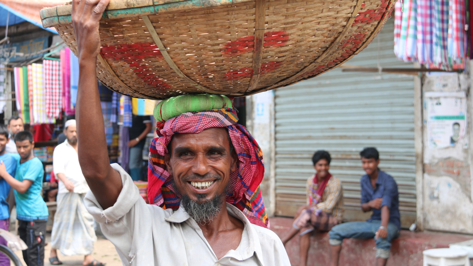smiling man with basket on head