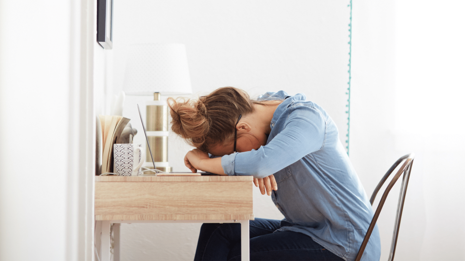 tired woman with her head down on desk