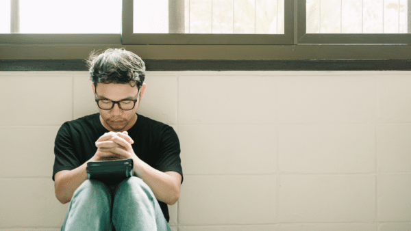A man sitting down and praying.