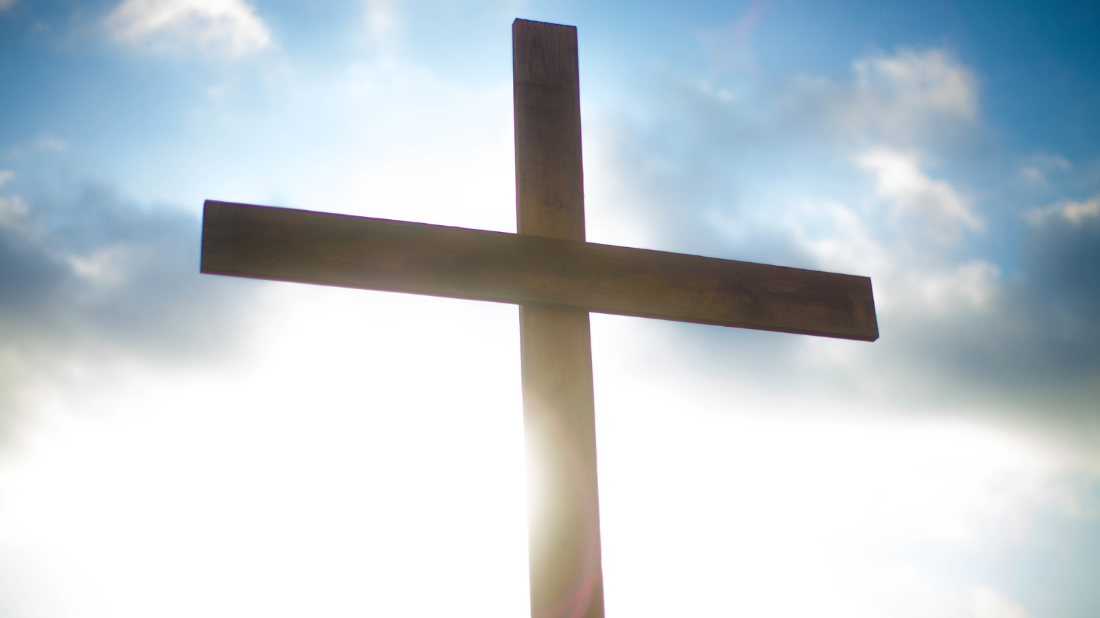 A wooden cross against a blue sky.