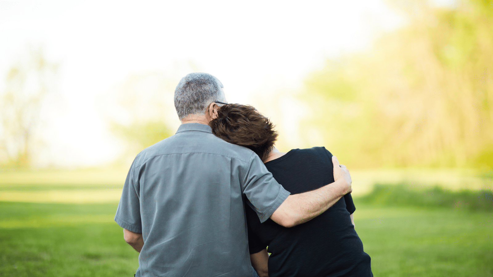 A man with his arm around a woman.