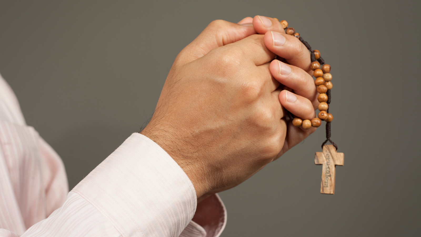 Hands holding a rosary.
