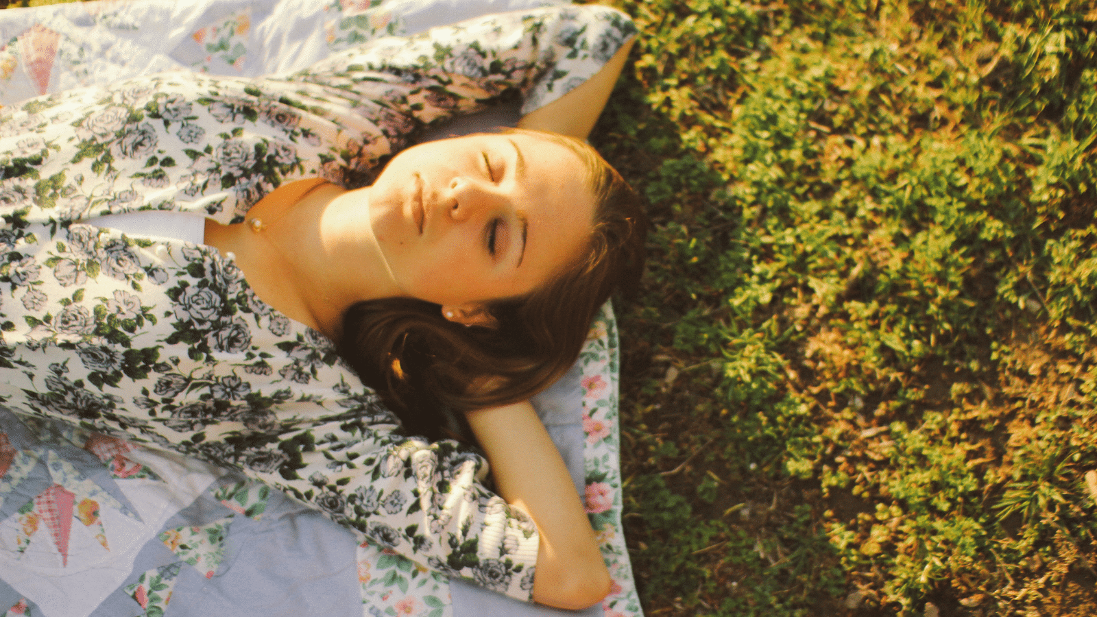 A woman laying down with her hands behind her head.