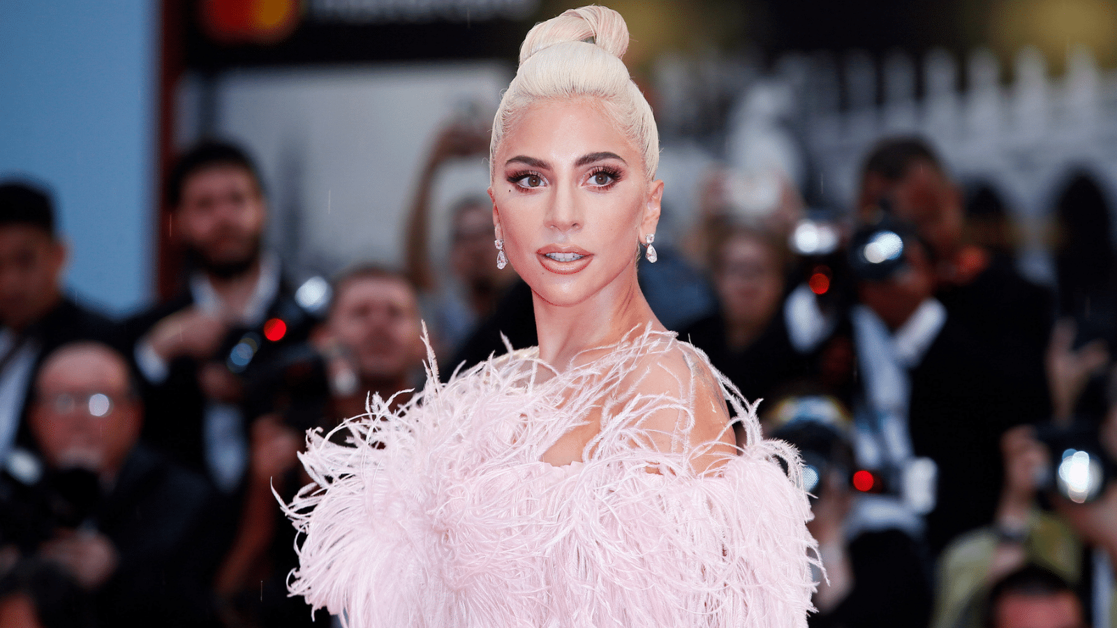 Lady Gagy wearing a pink feathery outfit.