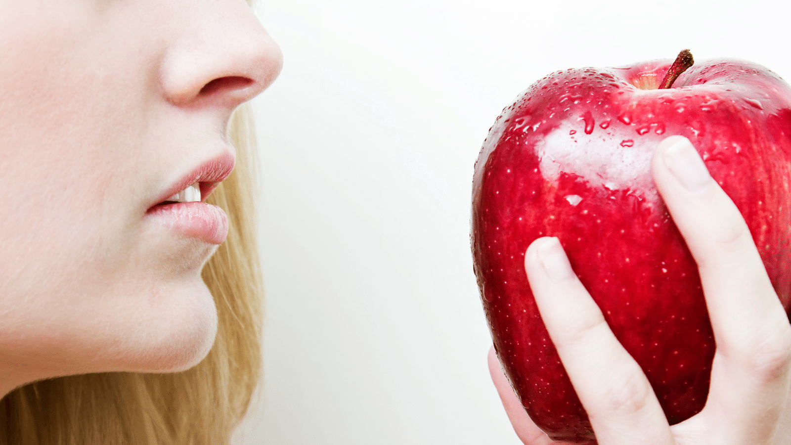 A woman holding a red apple.