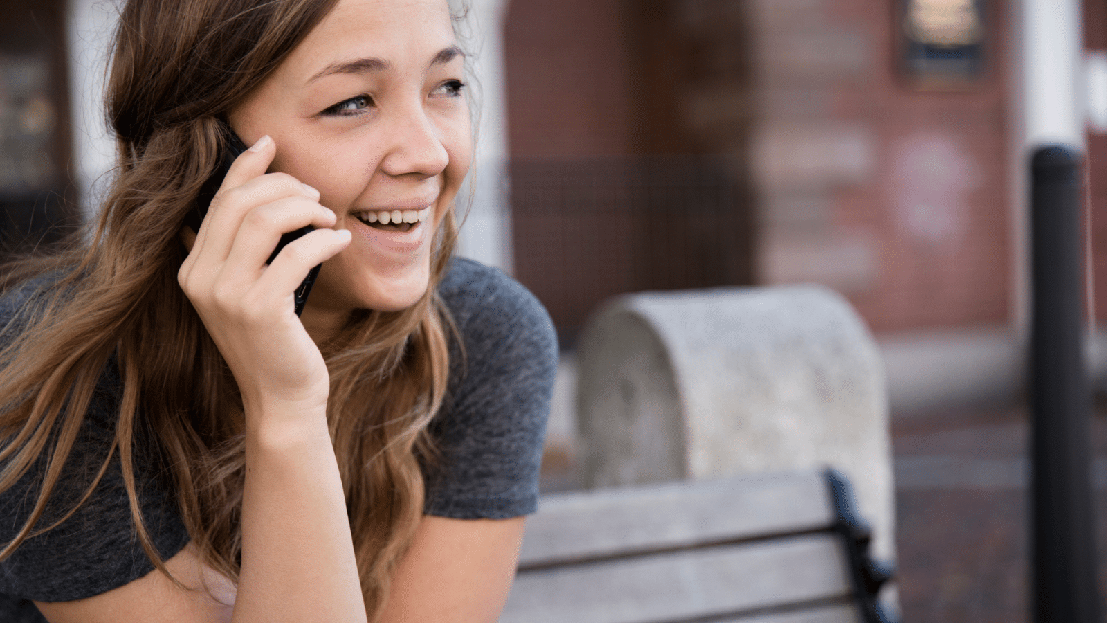 A woman talking on the phone outside.