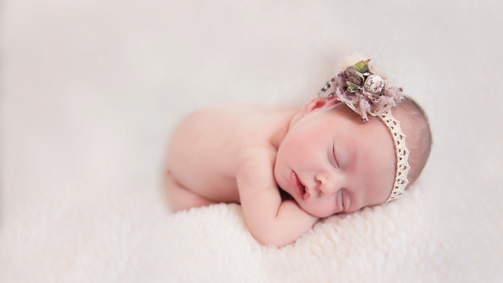 sleeping newborn girl with bow