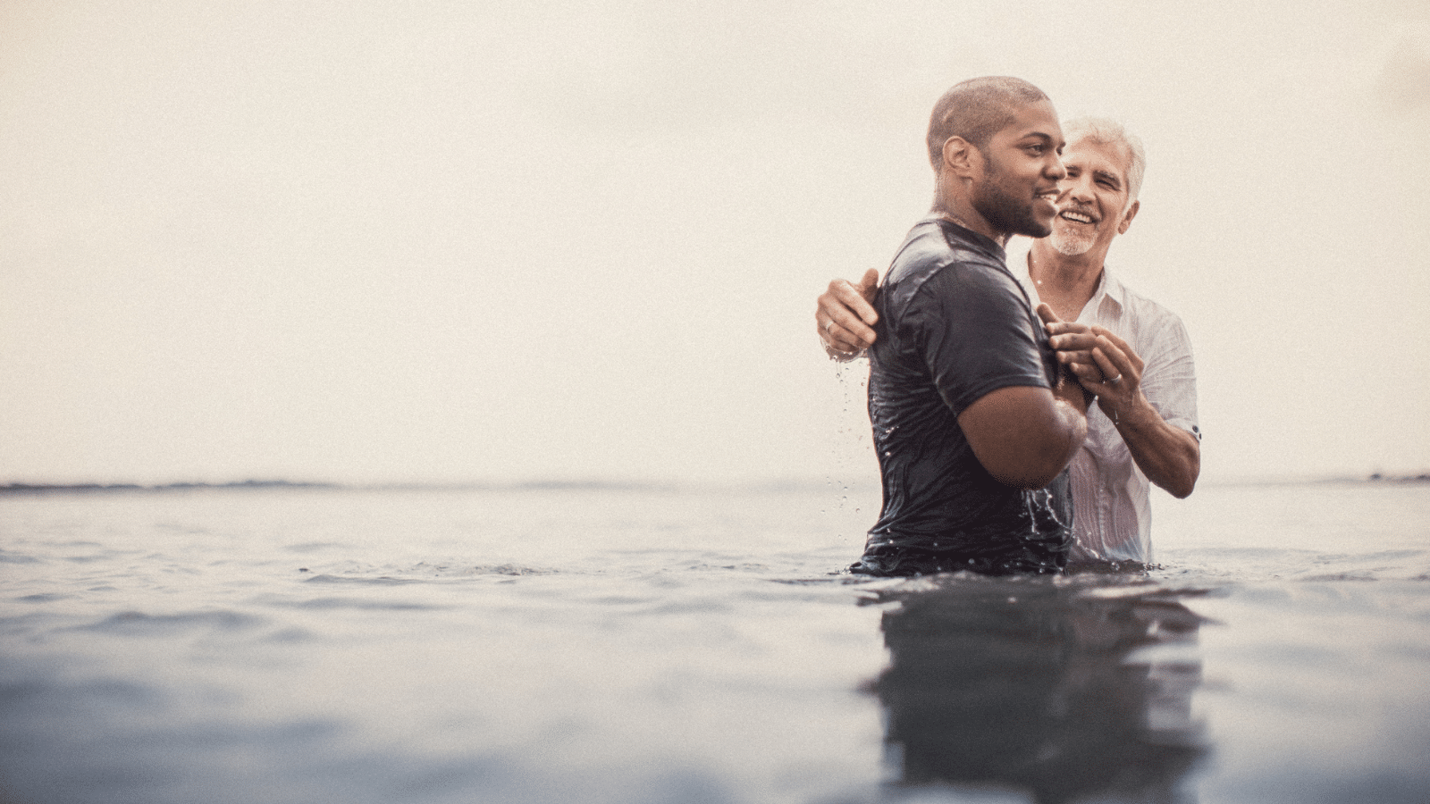 A man getting baptized in a body of water.