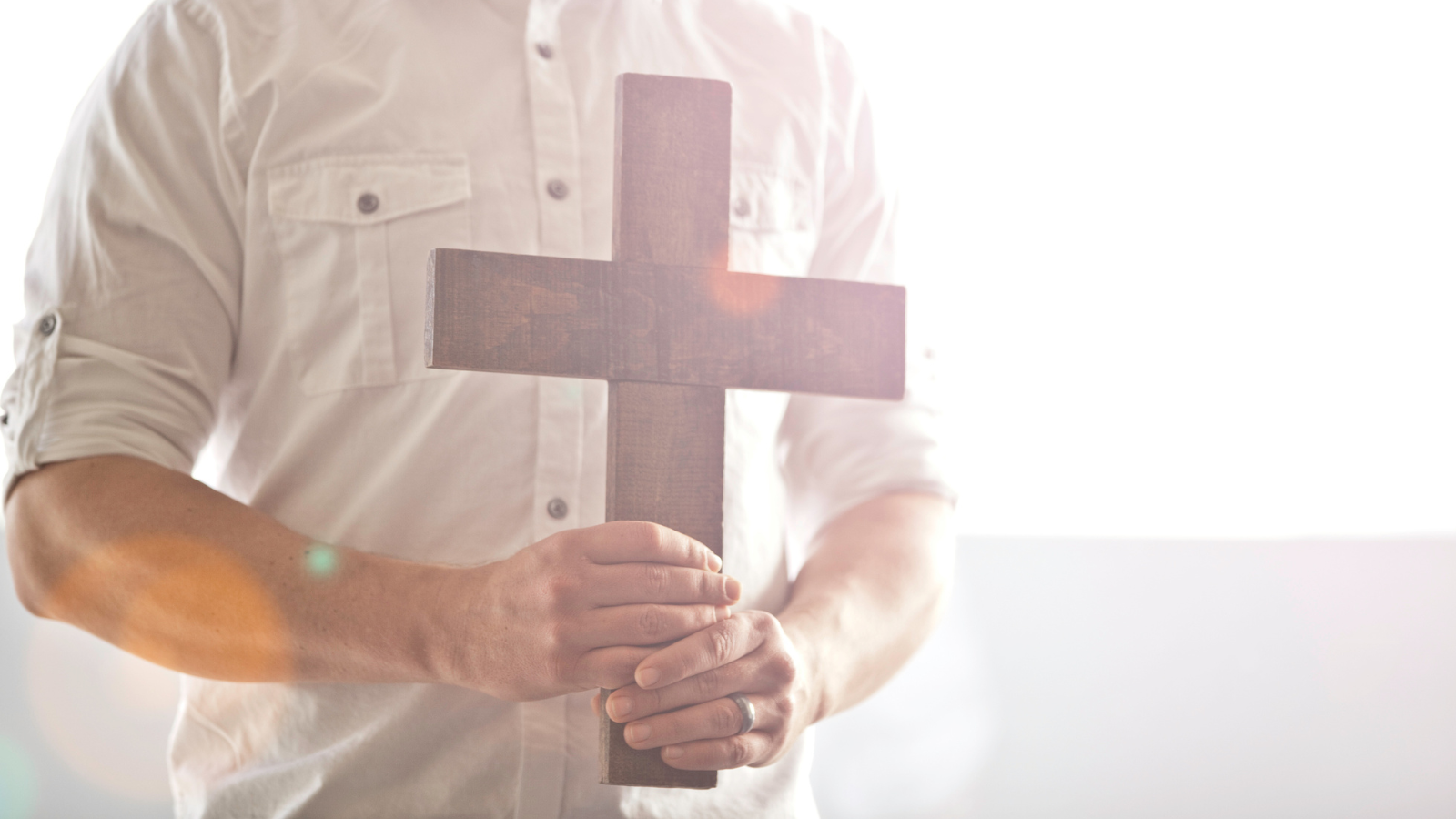 A man holding a wooden cross.
