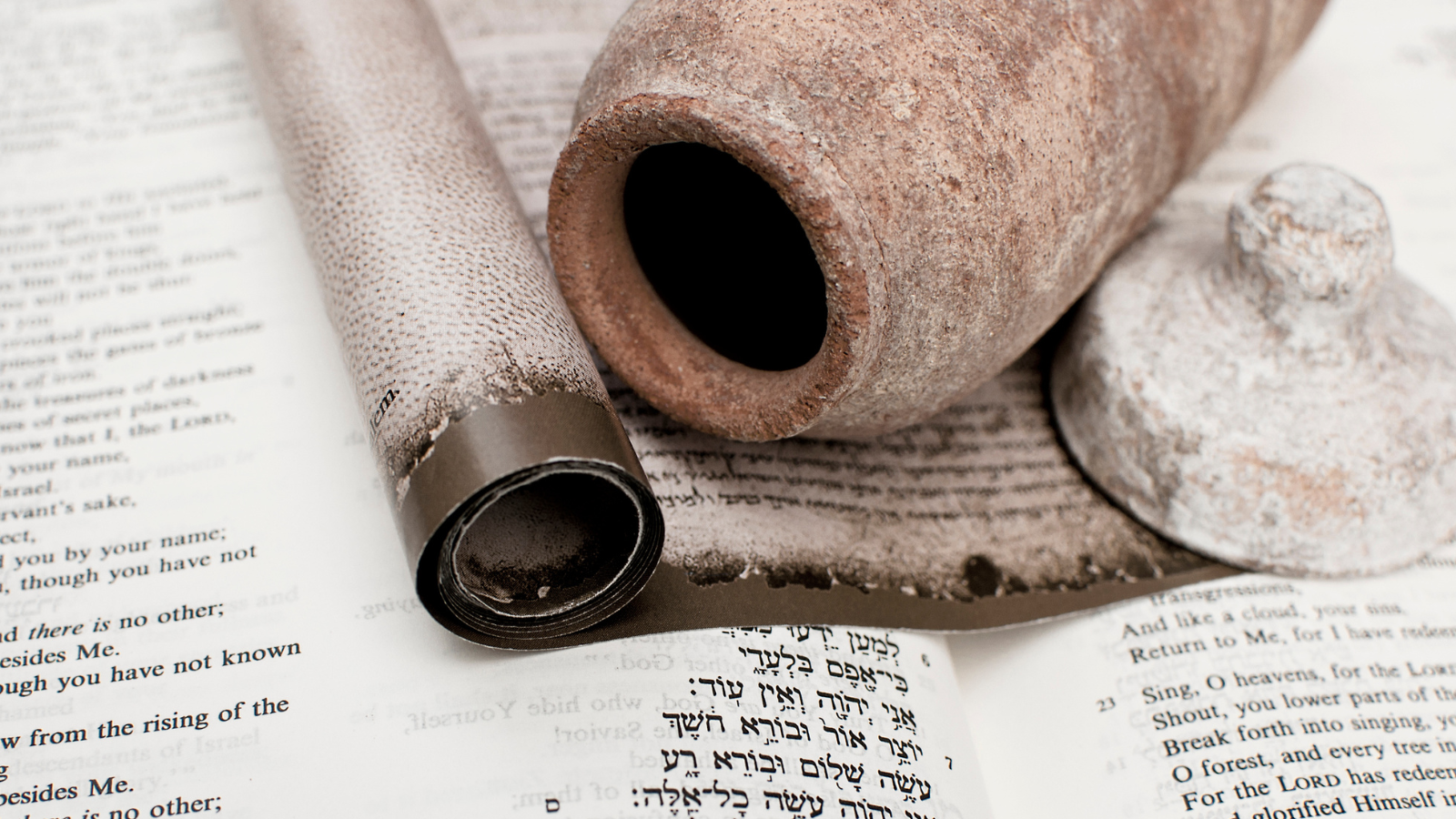 The dead sea scrolls laid on an open bible.