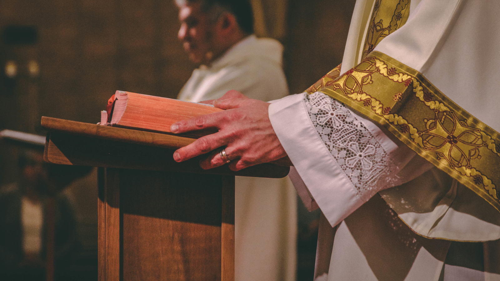 A preist holding a bible.