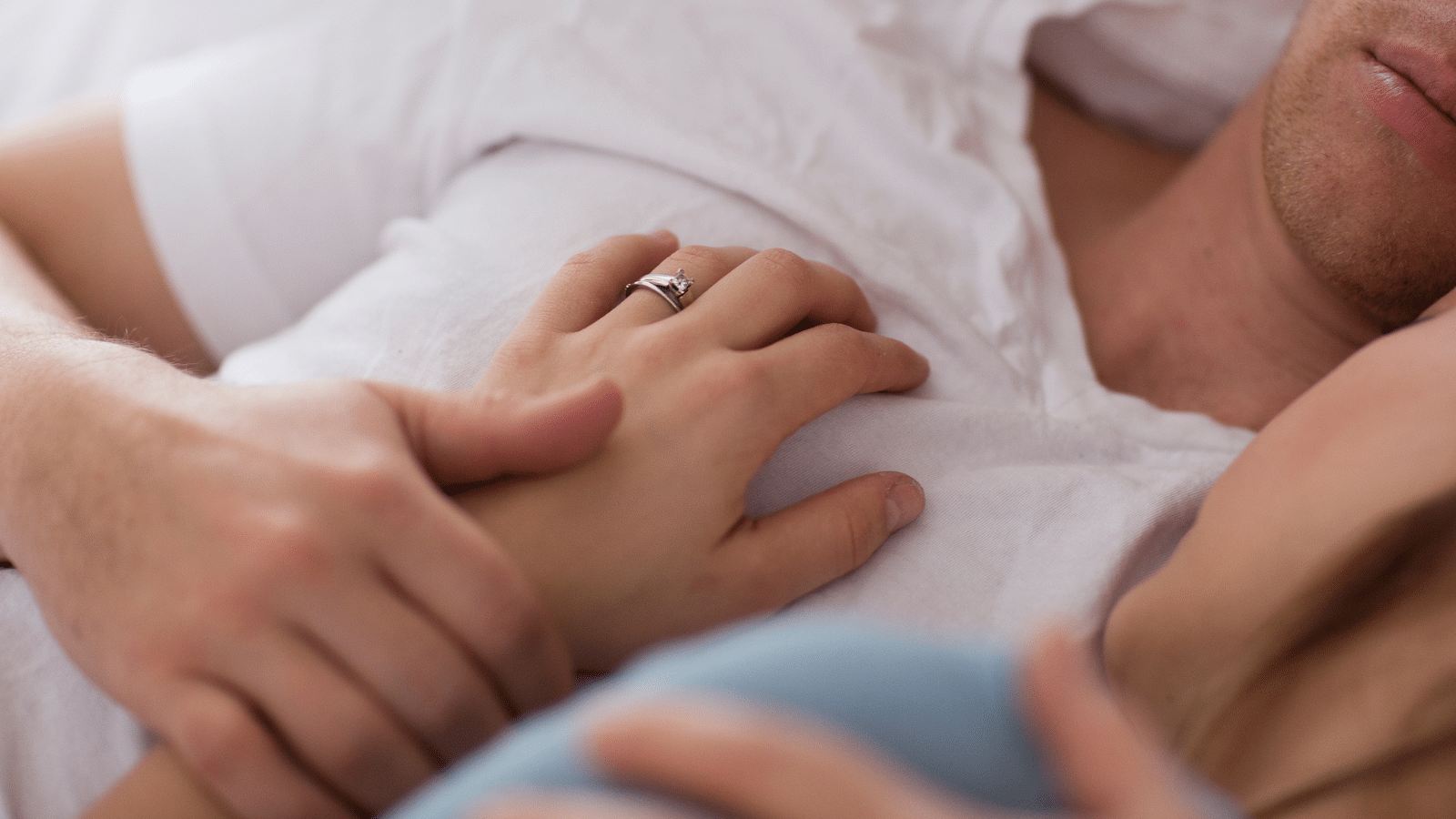 A man and a woman laying in bed together.