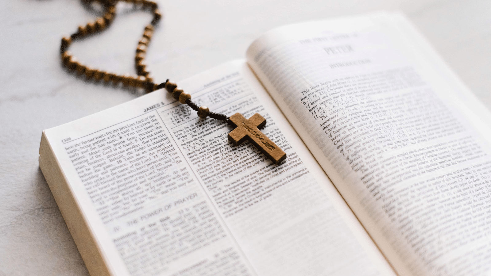 A rosary laying inside an open bible.