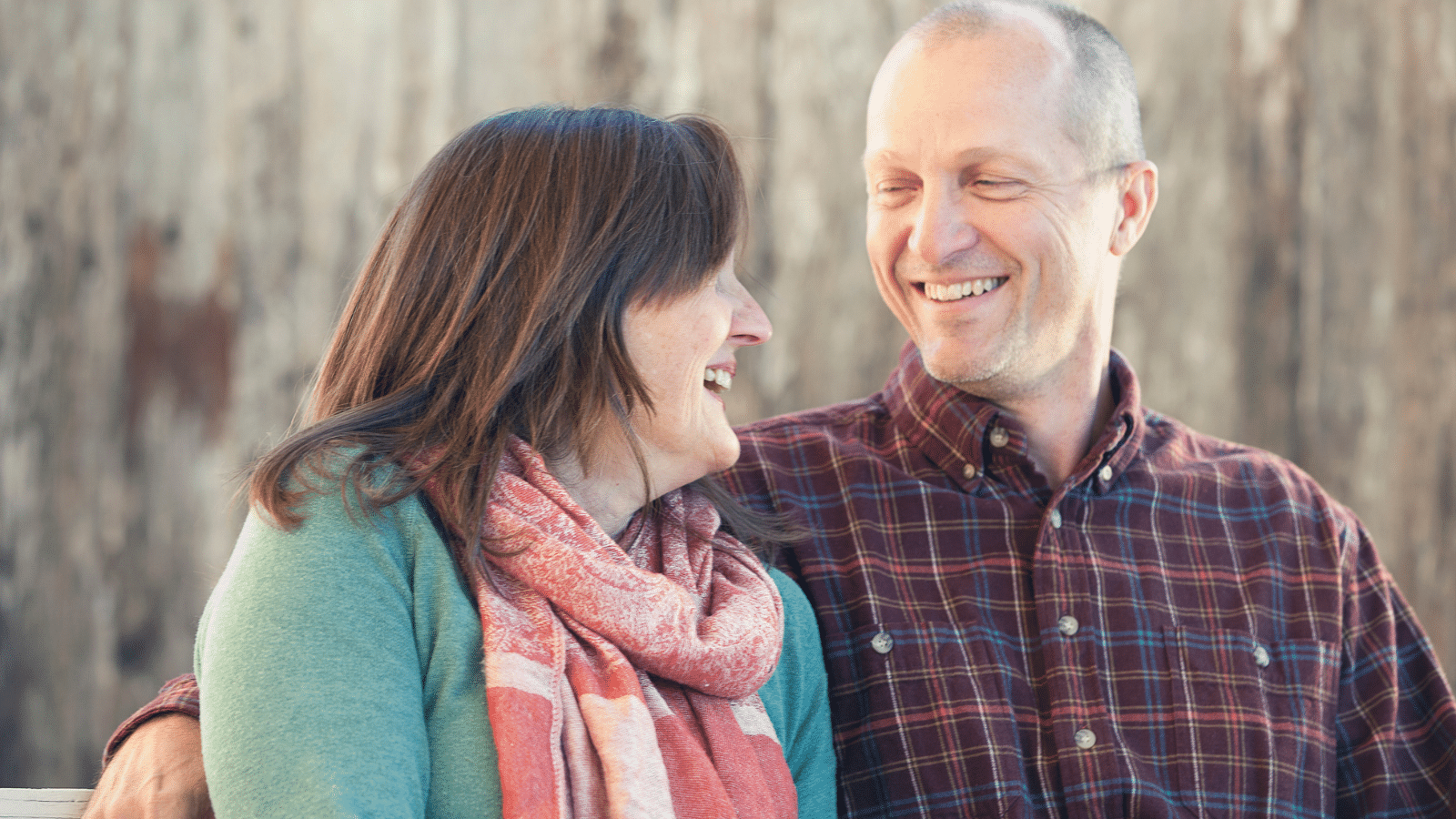 A man and a woman smiling at each other.