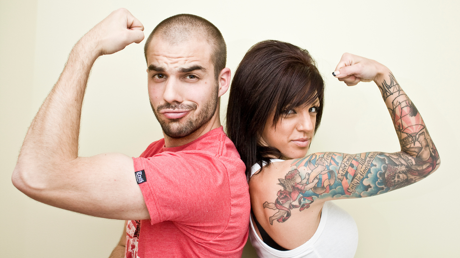 Couple showing off muscles lady with tattoos