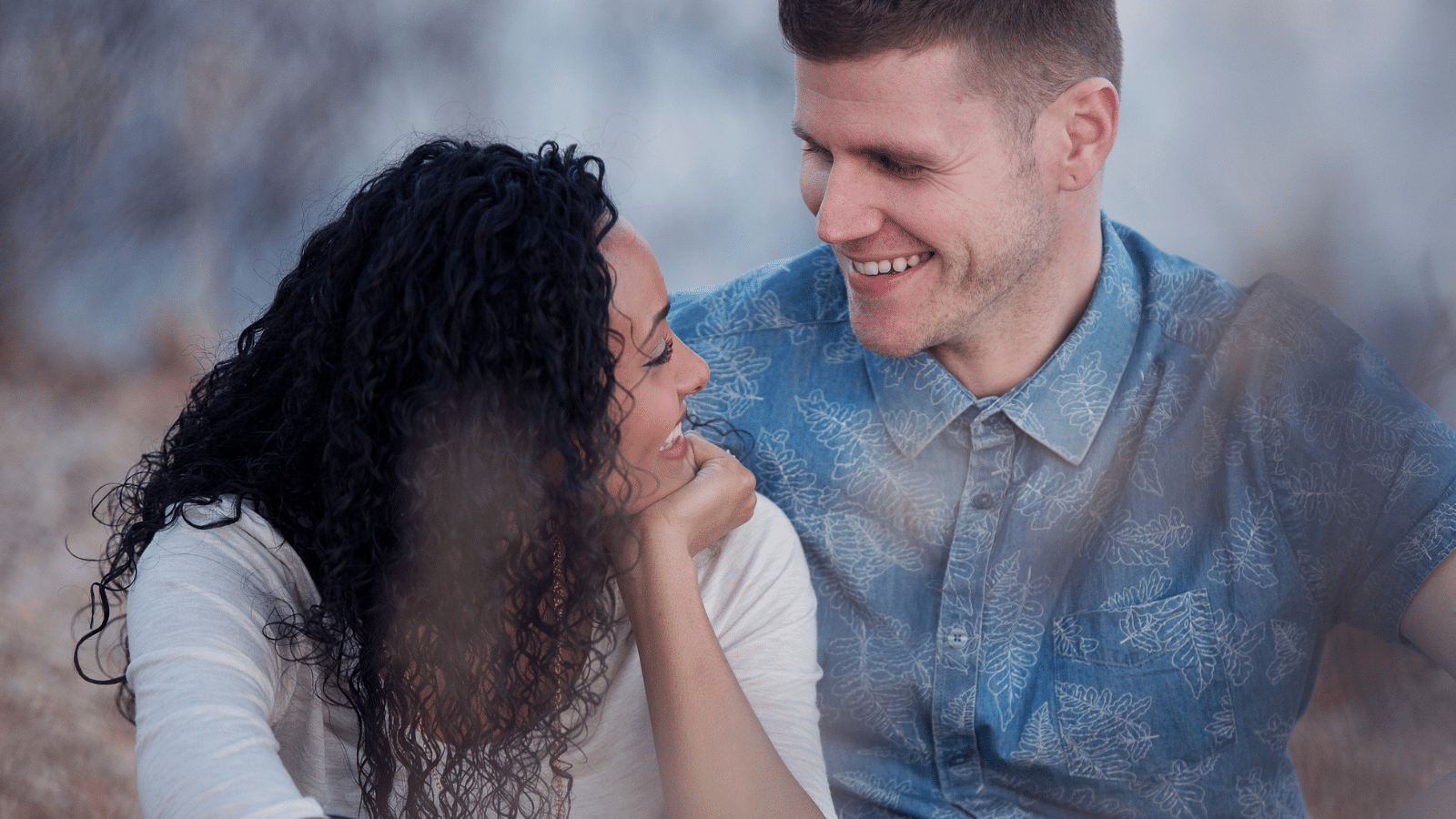 A man and a woman smiling at each other.