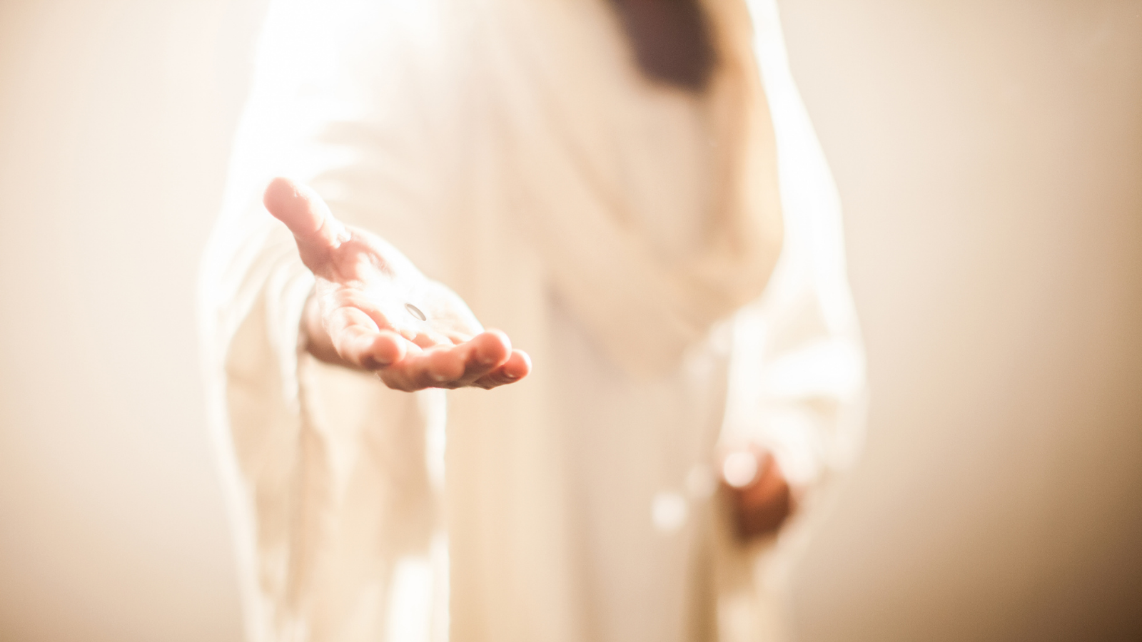 Jesus in a white robe holding out his hand.