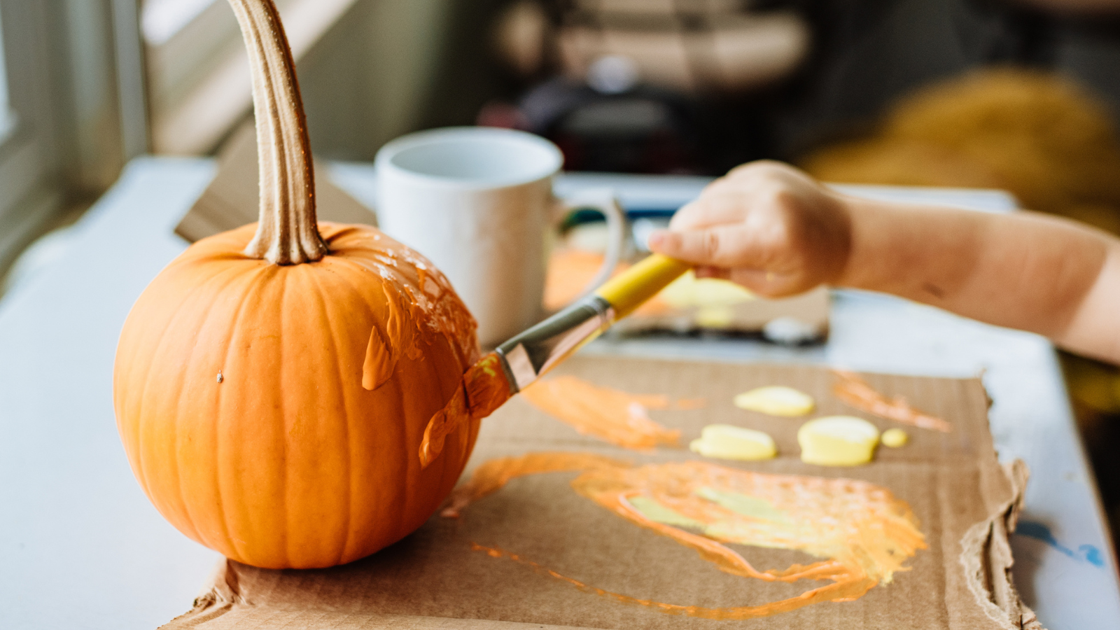Someone painting a pumpkin.