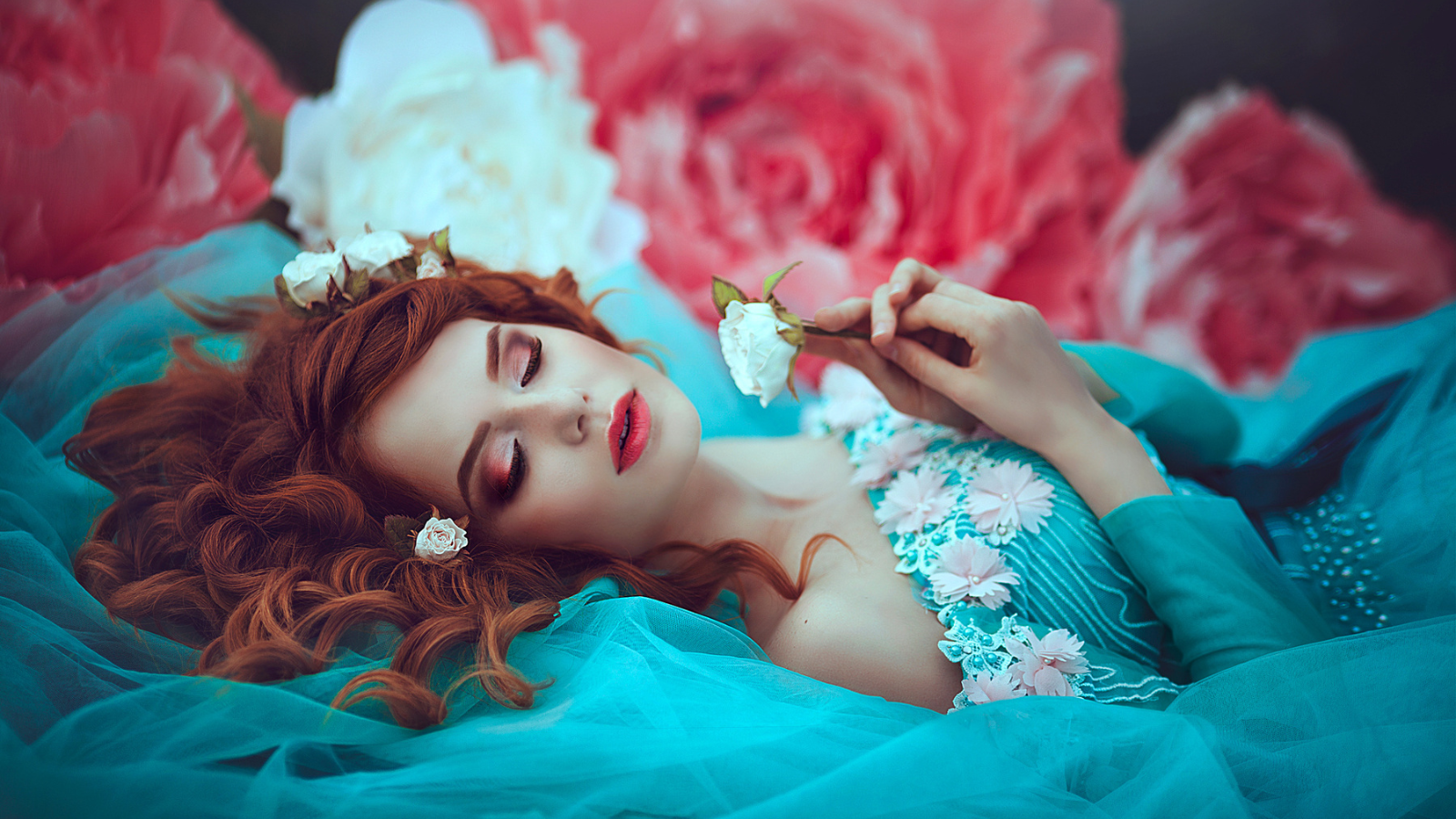 A woman wearing a princess dress and posing like Sleeping Beauty.