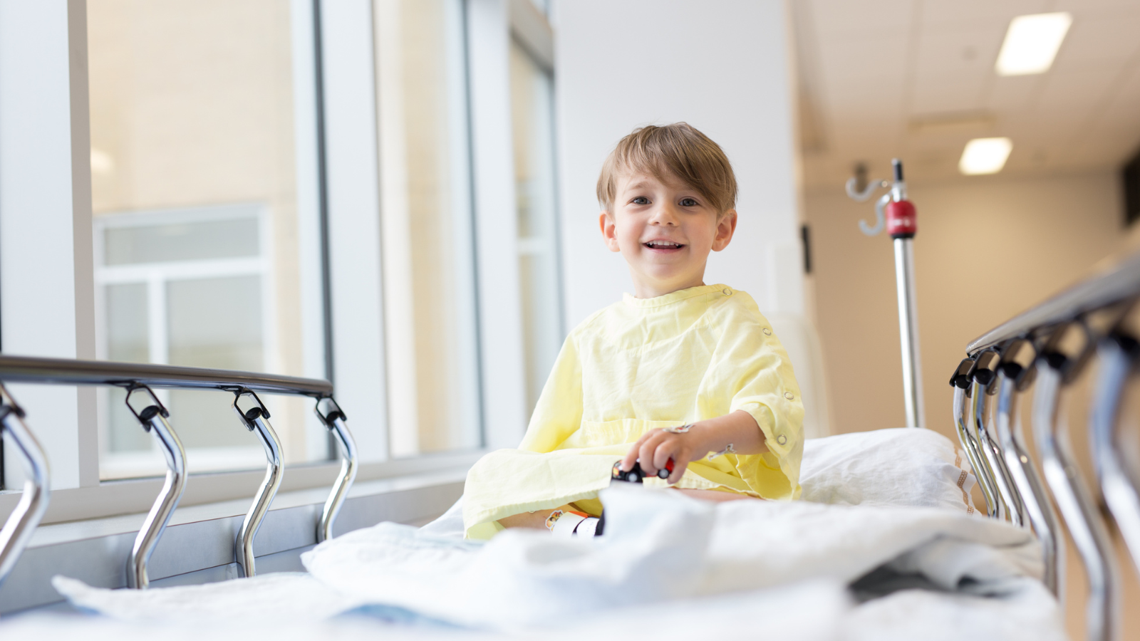 A child sitting on a hospital bed.